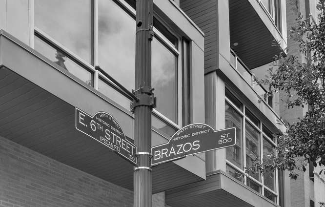 Street signs in front of Austin's Littlefield Lofts on 6th and Brazos
